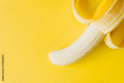 Close up view of peeled banana isolated on yellow background