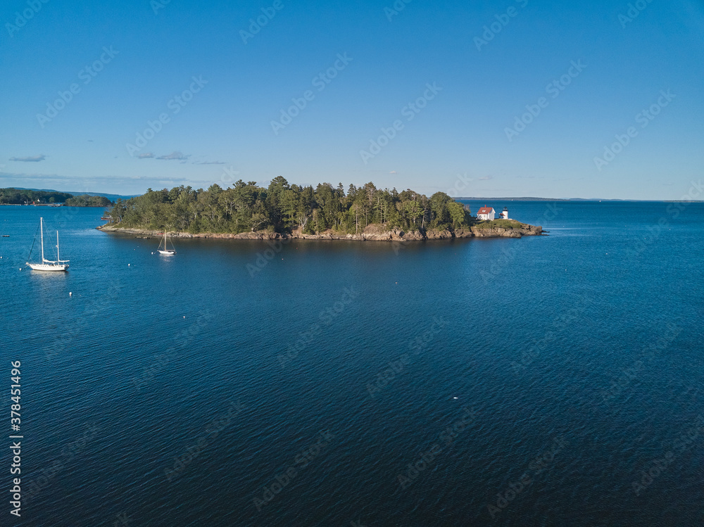 Aerial Drone image of the Curtis Island Lighthouse att he entrance to Camden Harbor on Penobscot Bay in Maine on a late afternoon