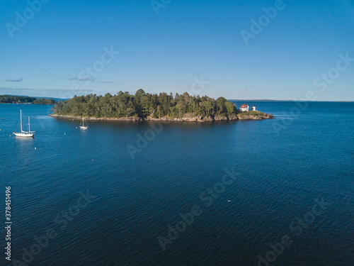 Aerial Drone image of the Curtis Island Lighthouse att he entrance to Camden Harbor on Penobscot Bay in Maine on a late afternoon