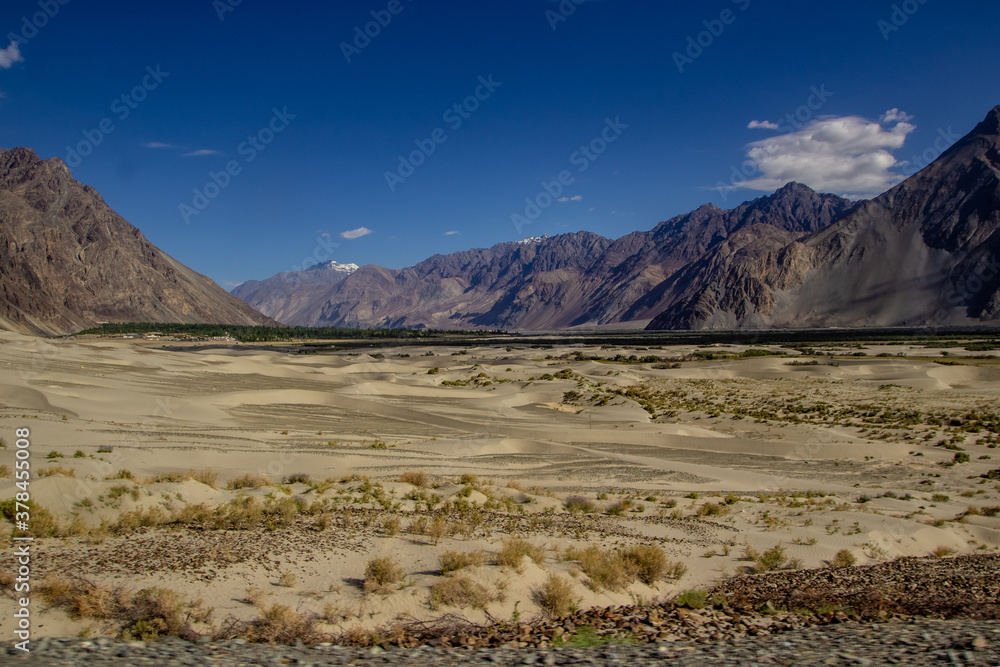 arid lands of ladakh with barren himalayan peaks viewable in distance with deep blue sky. arid lands of ladakh with barren himalayan peaks viewable in distance with deep blue sky.