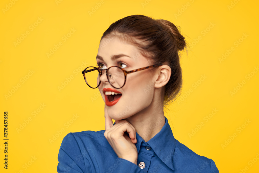 A woman in a blue shirt and glasses with bright makeup on her face is gesturing with her hands Copy Space