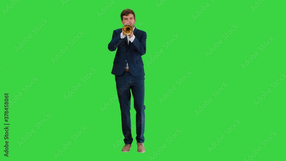 Man in suit standing playing trumpet on a Green Screen, Chroma Key. Man in suit standing playing trumpet on a Green Screen, Chroma Key.