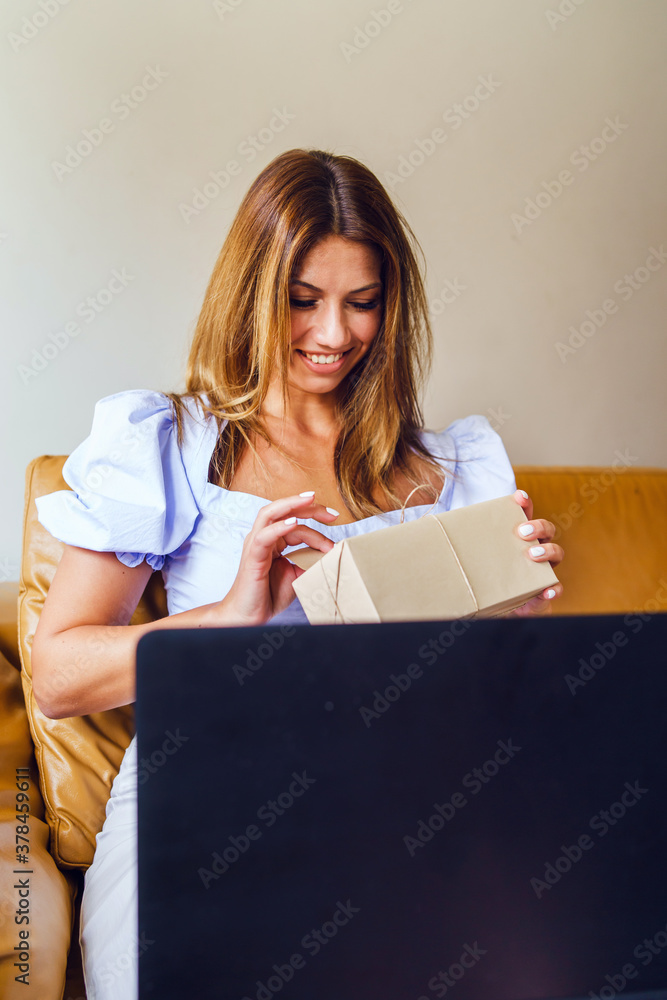 Happy caucasian woman smiling while open gift box birthday present at home in front of the laptop - Social distance celebration concept Happy caucasian woman smiling while open gift box birthday present at home in front of the laptop - Social distance celebration concept