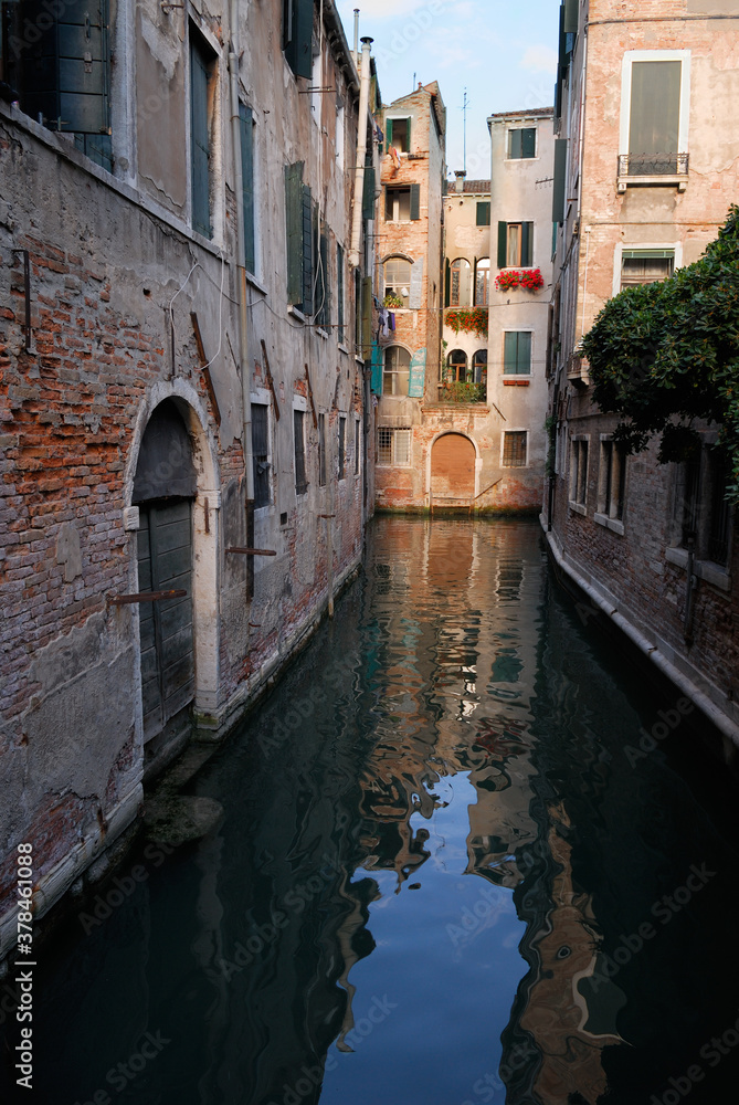 Narrow side canal with evening light in Venice