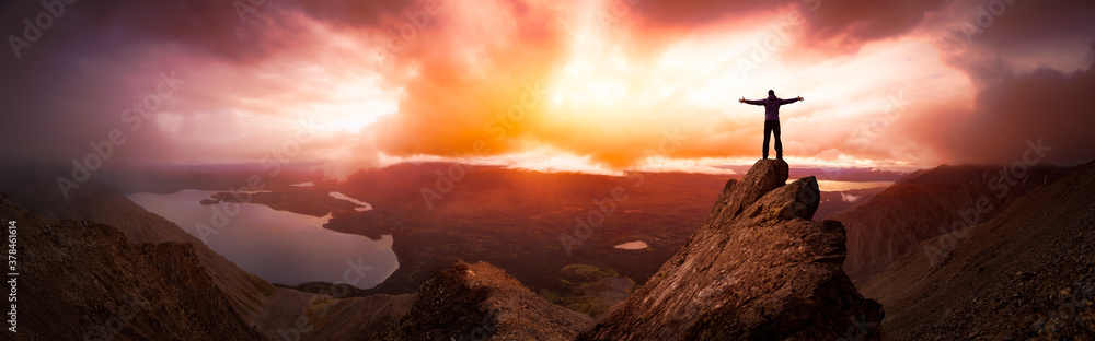Magical Fantasy Adventure Composite of Man Hiking on top of a rocky mountain peak. Background Landscape from Yukon, Canada. Sunset or Sunrise Colorful Sky Magical Fantasy Adventure Composite of Man Hiking on top of a rocky mountain peak. Background Landscape from Yukon, Canada. Sunset or Sunrise Colorful Sky