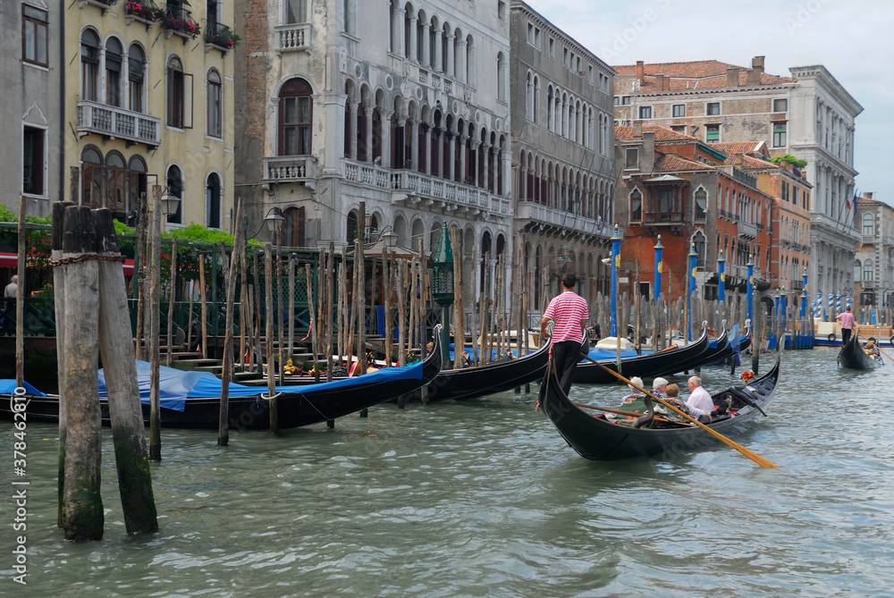 Gondoliers passing moored gondolas on the Grand Canal Venice