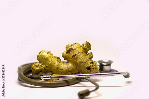 ginger and stethoscope isolated in white background as doctor recommendation health and nutrition purpose with room for text. Medicinal use of ginger.