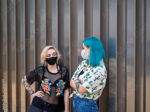 Wallpaper Mural Mujeres jóvenes con mascarilla hablando respetando las medidas de seguridad y distanciamiento social de la pandemia del coronavirus Torontodigital.ca