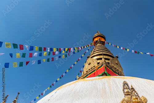 Tower of the Boudhanath Stupa decorated with flags in Kathmandu, Nepal.