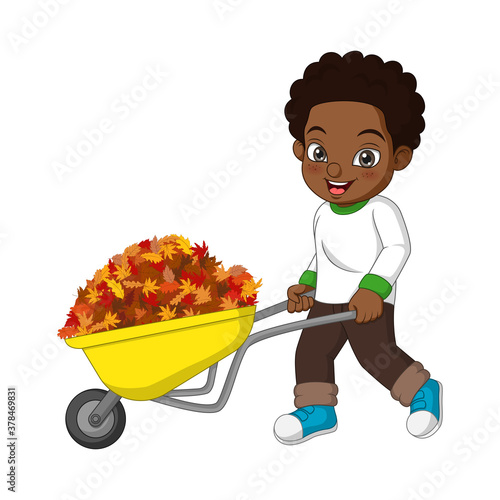 Cute african american boy pushing the cart with autumn leaves