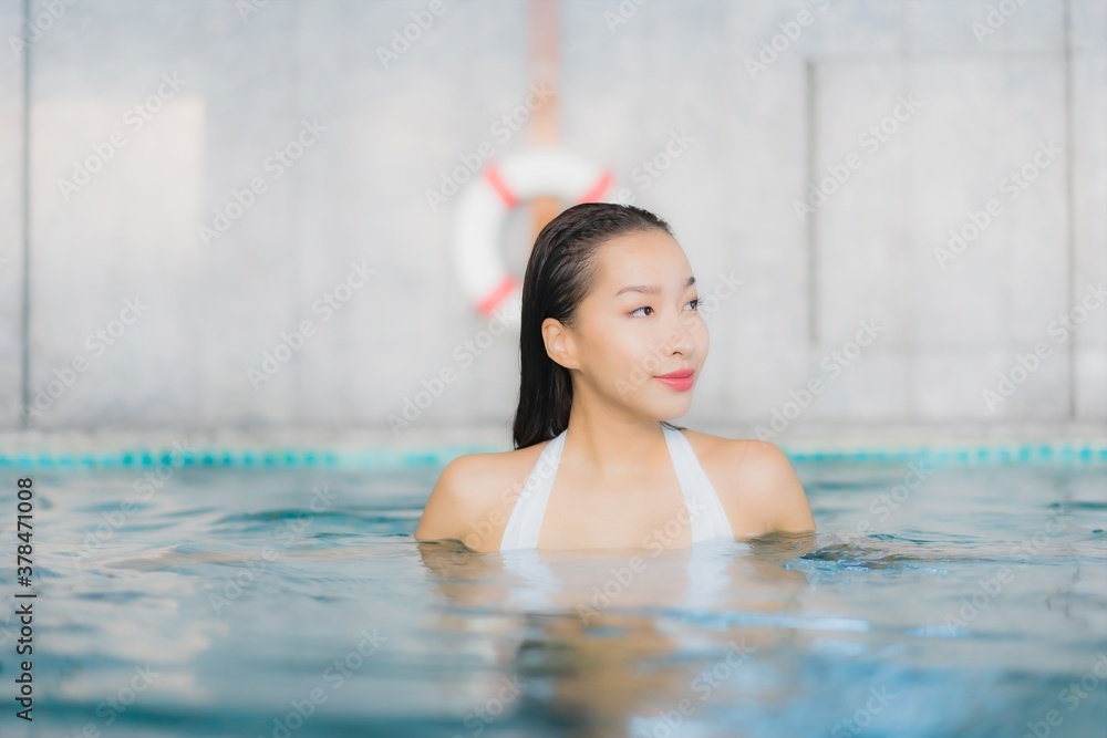 Portrait beautiful young asian woman relax smile around swimming pool in hotel resort
