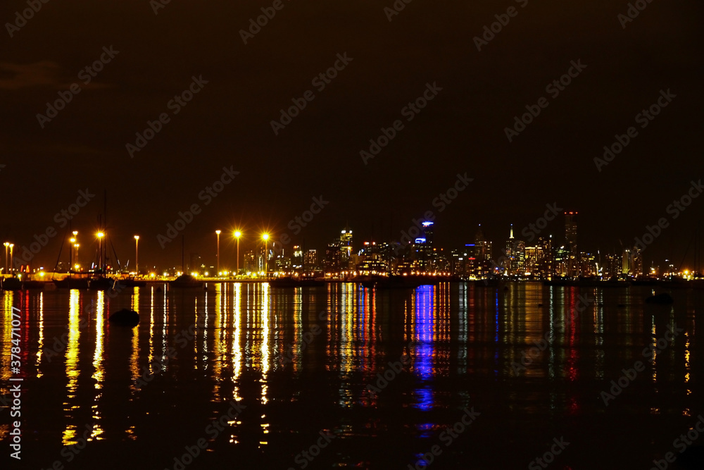 The Melbourne city skyline at night with lights on Port Phillip Bay