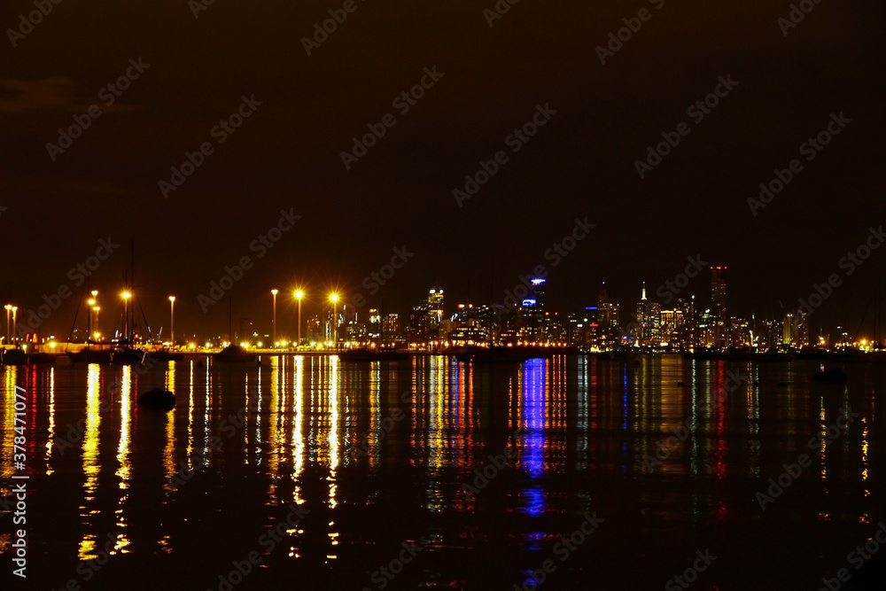 The Melbourne city skyline at night with lights on Port Phillip Bay The Melbourne city skyline at night with lights on Port Phillip Bay