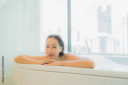 Portrait beautiful young asian woman relax in bathtub interior of bathroom
