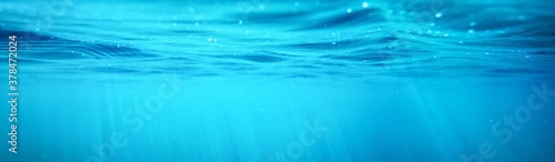 Picturesque panoramic underwater view. Sunbeams in turquoise water. Abstract natural texture, pattern, background, wallpaper, graphic resource. Sea, river, lake, pure nature, environment