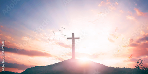Religious concept: Silhouette cross and birds flying on sunrise background