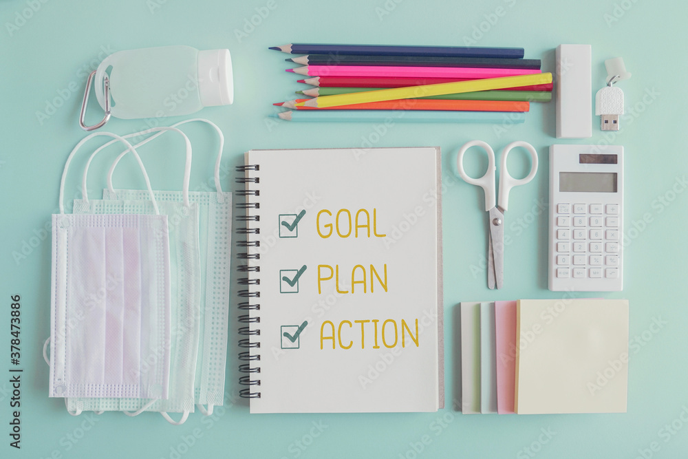 2021 New year resolution, Goal, Plan and action on notepad and stationery supplies, medical masks and hand gel sanitizer 2021 New year resolution, Goal, Plan and action on notepad and stationery supplies, medical masks and hand gel sanitizer