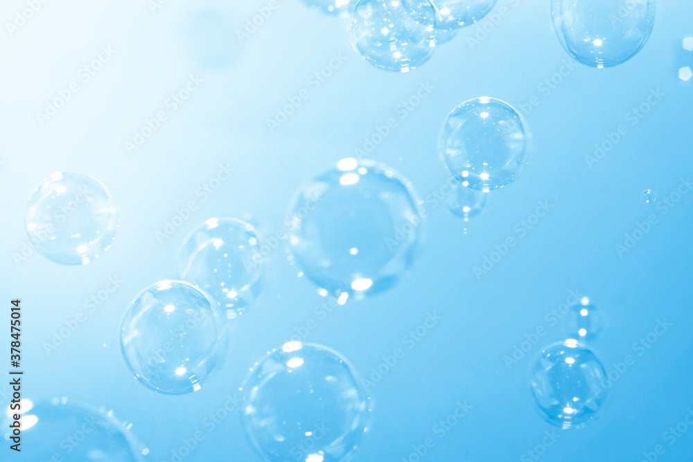 Blue soap bubbles float in the air. Freshness summer nature background.