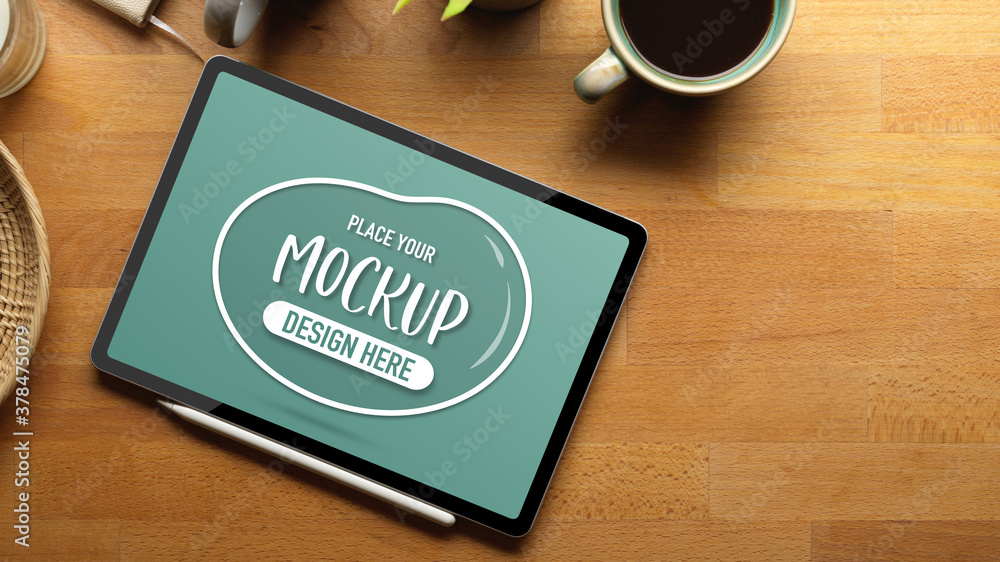 Mock up digital tablet on wooden table with copy space, coffee cup and supplies Mock up digital tablet on wooden table with copy space, coffee cup and supplies