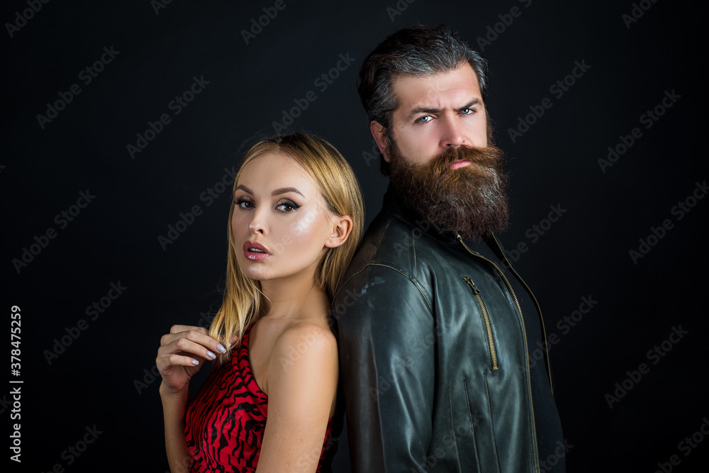 Fashion girl and guy in outlet clothes posing on a black background. Trendy look. Fashion girl and guy in outlet clothes posing on a black background. Trendy look.