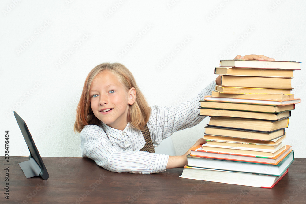 Teenage girl pushes books aside, choosing a tablet for learning. Teenage girl pushes books aside, choosing a tablet for learning.