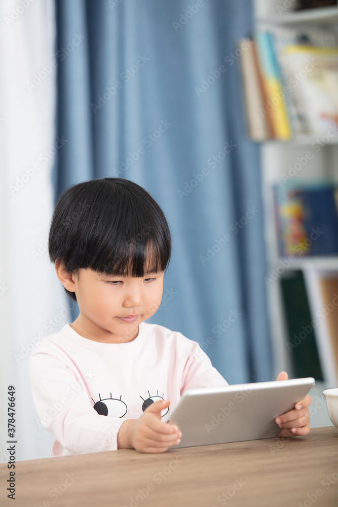 Child looking at tablet computer after meal
Child looking at tablet computer after meal