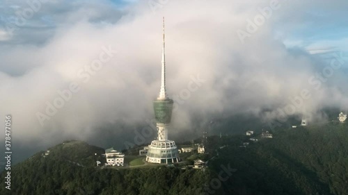 The TV transmission tower under the blue sky and white clouds