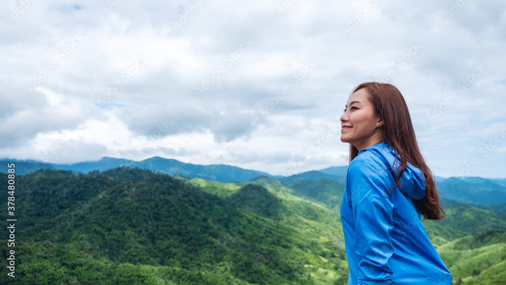Portrait image of female traveler with a beautiful green mountains view Portrait image of female traveler with a beautiful green mountains view