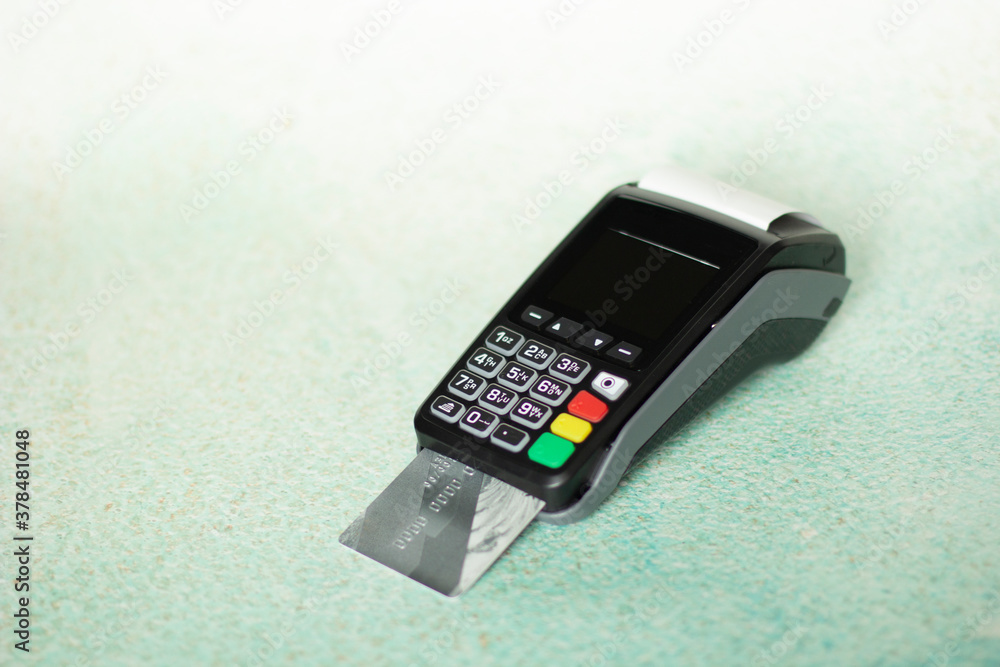 Hand swiping credit card in wireless modern bank. Payment with NFC tecnology and POS terminal on light background