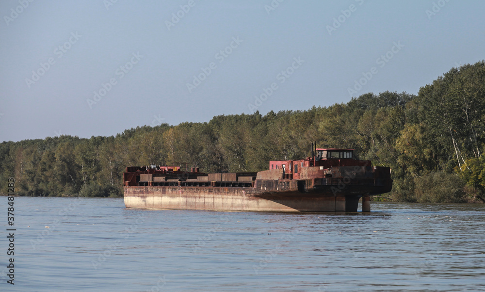 Rusty barge is anchored on the Danube river