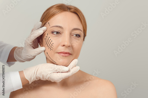 Plastic surgeon examining w...