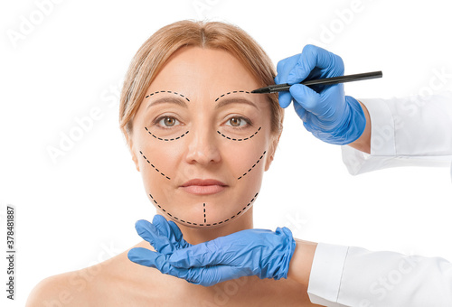 Plastic surgeon applying ma...