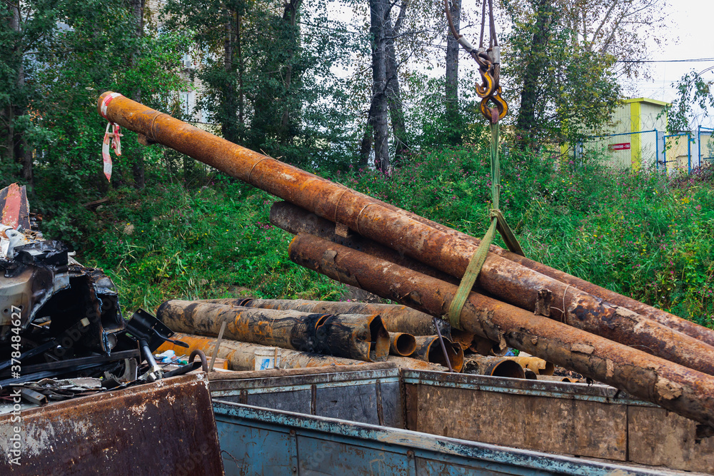 Scrap yard, unloading old pipes with a crane. Scrap yard, unloading old pipes with a crane.