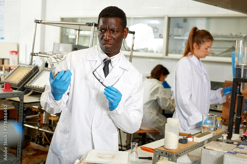 Obraz premium Focused lab technician checking for result of experiment in modern aboratory