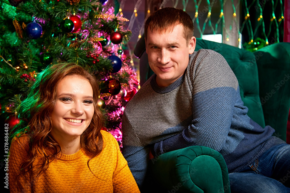 Fototapeta premium Happy couple in love in the room decorated for Christmas or New Year.