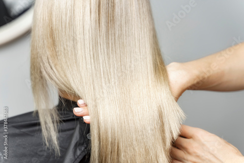 stylist calorist shows model's dyed blond hair