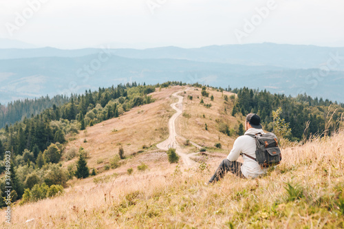 man with backpack hiking by autumn mountains