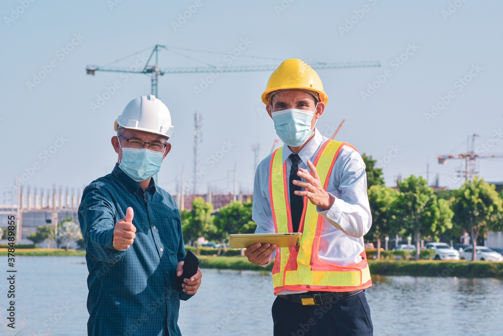 Businessman in medical mask talking on site construction by tablet technology Businessman in medical mask talking on site construction by tablet technology
