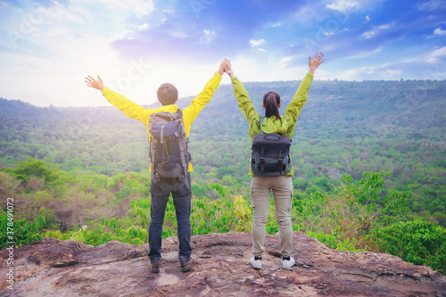 Couples hiker standing and open arms on mountain peak celebrate their freedom vacation 