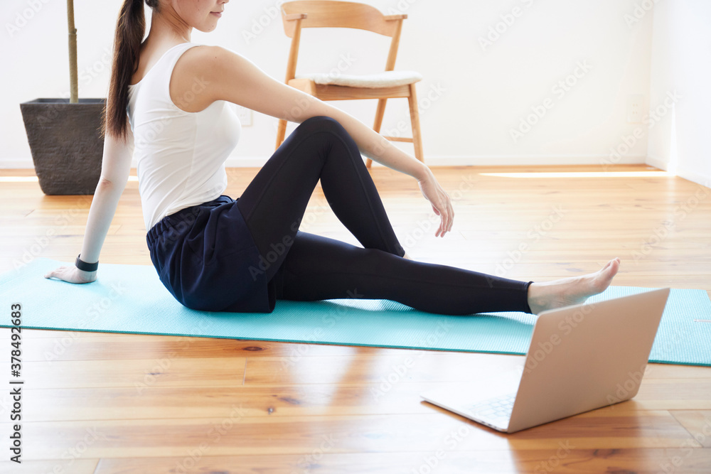 Obraz premium 部屋の中で運動をする若い女性