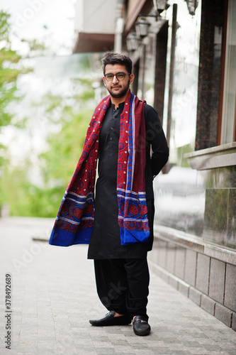 Pakistano bangladesh man wear black traditional clothes and eyeglasses pose outdoor.