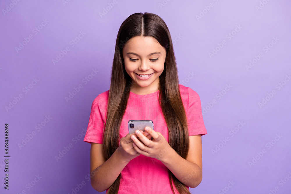 Portrait photo of small pretty girl using smartphone reading information in mass media isolated on purple color background Portrait photo of small pretty girl using smartphone reading information in mass media isolated on purple color background