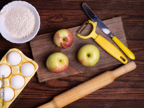 The concept of seasonal Apple baking. Ingredients for Apple pie on a rustic wooden table.