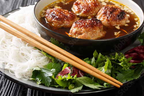 Foto Bun cha is a Vietnamese dish of grilled pork, noodle and herb closeup in the plate on the table