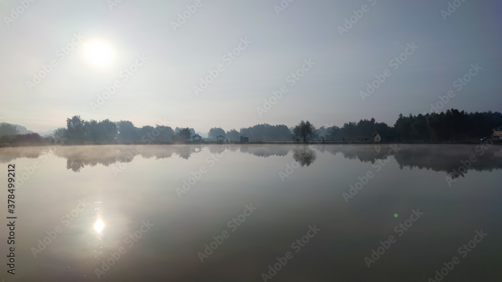 Fishing lake in the foggy morning