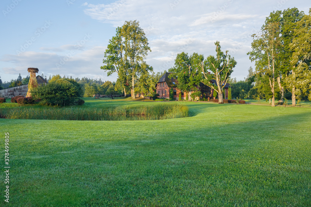 Naklejka premium City Talsi, Latvia. Old red brick house and park.