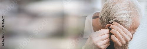 Fotografía Man putting hearing aids; panoramic banner