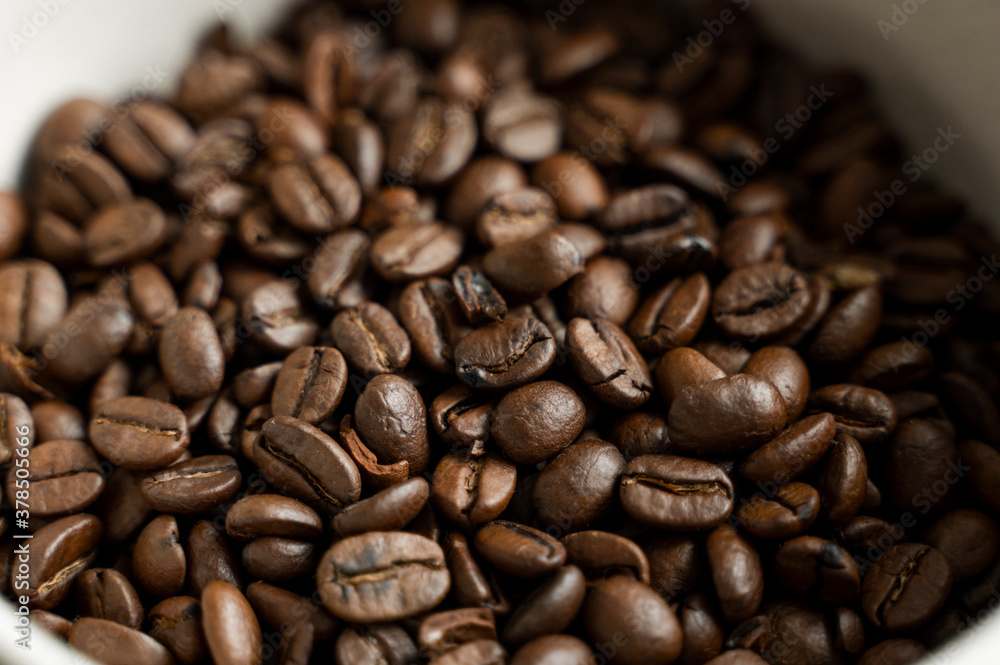 Bowl filled of fresh arabica or robusta coffee beans on a wooden table. Bowl filled of fresh arabica or robusta coffee beans on a wooden table.