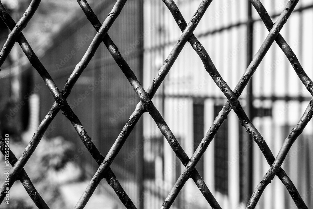 black and white texture of trapeze shaped iron grate of a gate