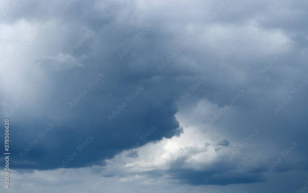 Majestic low rain clouds with sunlight over horizon. Stormy sky..